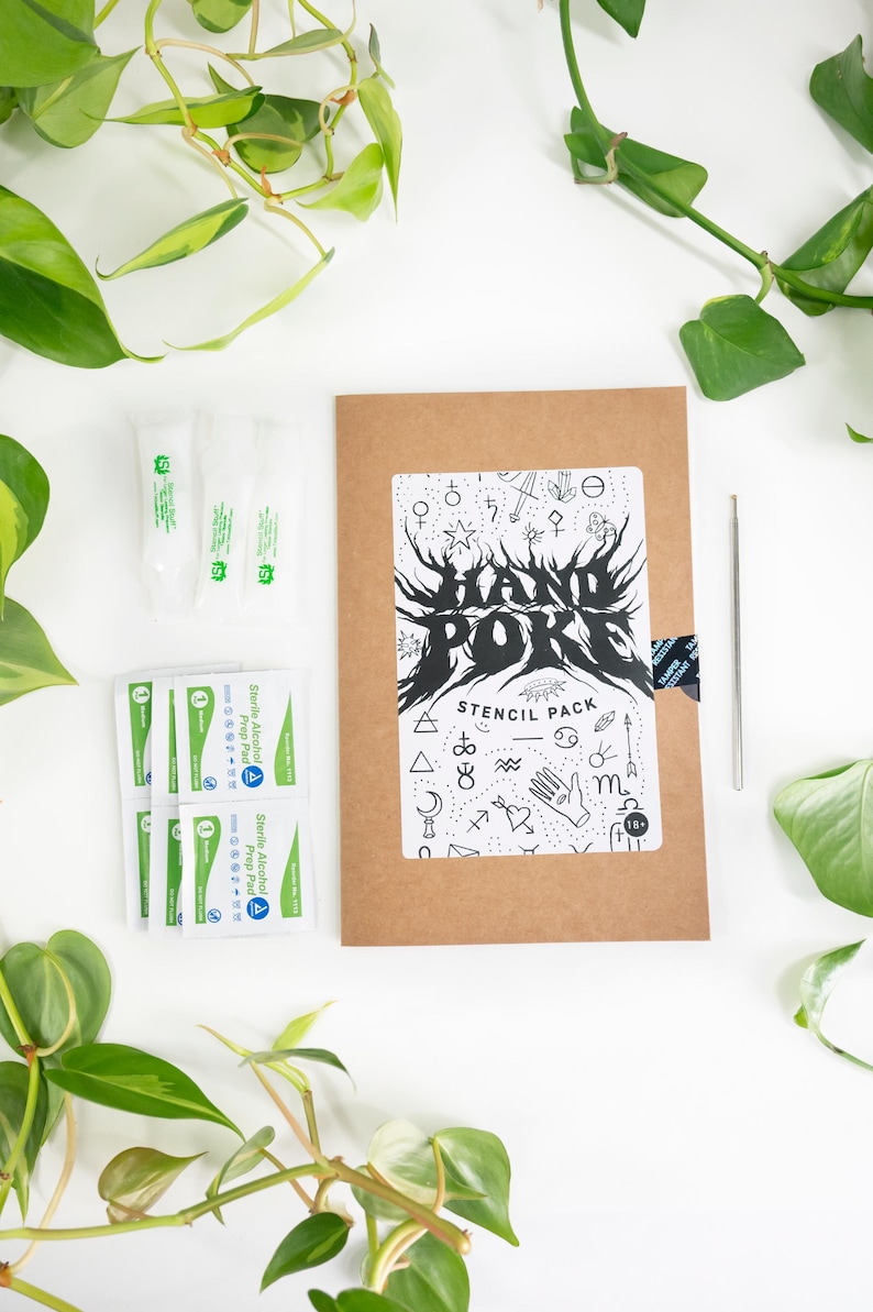 May include: A brown stencil pack with the text "HAND POKE STENCIL PACK" and various black and white illustrations. Also included are sterile alcohol prep pads and a metal tool. Green plants surround the items.