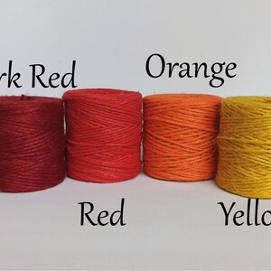 Op de afbeelding: Vier strengen touw in tinten donkerrood, rood, oranje en geel. De kleuren zijn gelabeld met bijbehorende tekst. Het touw is strak opgerold en de afbeelding staat tegen een effen witte achtergrond.