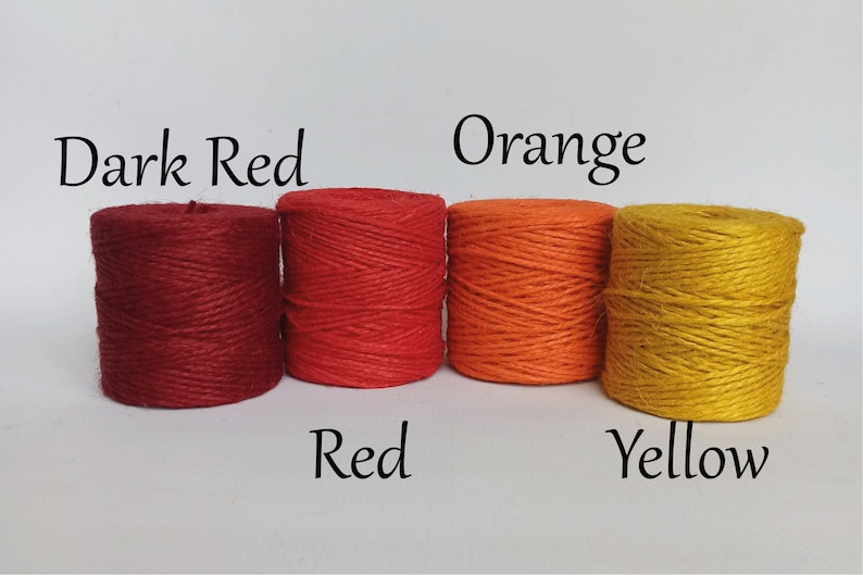 Op de afbeelding: Vier strengen touw in tinten donkerrood, rood, oranje en geel. De kleuren zijn gelabeld met bijbehorende tekst. Het touw is strak opgerold en de afbeelding staat tegen een effen witte achtergrond.