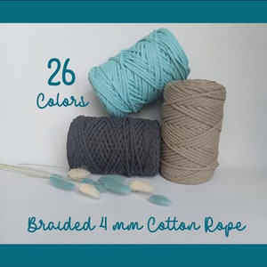 Peut inclure: Trois bobines de corde en coton tressé de 4 mm, en bleu sarcelle, gris et beige. L'image comprend le texte "26 Couleurs" et "Corde de coton tressée 4 mm". Des fleurs séchées décoratives sont au premier plan. Idéal pour le macramé et autres travaux manuels.