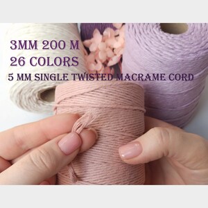 Puede incluir: Tres carretes de cordón de macramé de 5 mm de grosor, trenzado simple. El cordón está disponible en blanco, rosa y lavanda. El texto de la imagen dice "3 mm 200 m 26 colores 5 mm cordón de macramé trenzado simple".