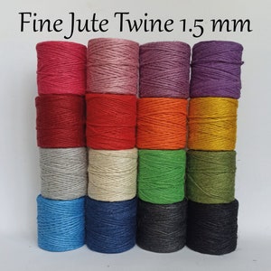 Op de afbeelding: Spoelen fijn jute touw in diverse kleuren, waaronder rood, roze, paars, oranje en groen. De tekst "Fine Jute Twine 1.5 mm" staat bovenaan. Het touw is strak opgerold en klaar voor knutselen of andere toepassingen.