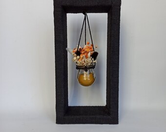 Boho Home Decor - Glass jars with dried flowers and beeswax on the wooden stand wrapped with black cotton rope