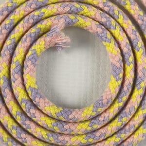 May include: A coiled length of braided rope featuring a repeating pattern of pastel yellow, soft pink, and light lavender fibers. The rope is wound in a circular spiral formation, with the frayed end of the cord visible at the center of the coil.