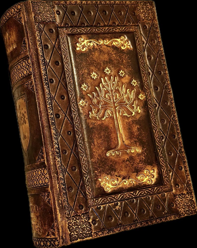 May include: A detailed, antique-style book with a brown leather cover. The cover features a gold embossed tree design with stars, and ornate gold borders. The book's spine and edges are also intricately decorated, creating a vintage aesthetic.