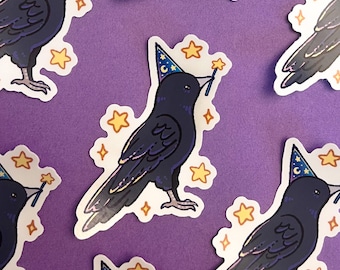 Pode incluir: Um conjunto de adesivos com um corvo preto usando um chapéu de mago azul e branco e segurando uma varinha mágica. O corvo está rodeado de estrelas amarelas em um fundo roxo.