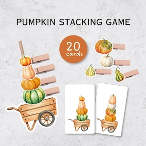 Peut inclure: Un jeu d'empilage de citrouilles comprenant 20 cartes, des pinces à linge en bois et des illustrations de citrouilles de formes et de couleurs variées empilées sur des brouettes en bois. Les cartes présentent des citrouilles à l'aquarelle.