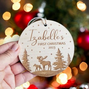 Personalisierte Babys erste Weihnachtsbaumkugel - runde Holzverzierung mit Weihnachtswald und Winterelchdesign