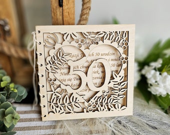 May include: A wooden card with a heart-shaped cutout and floral designs. The card is decorated with the number 50 and the text "Razji Tu ich 50 urodzin".