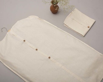 May include: A white garment bag with a zipper closure and four buttons down the front. The bag is made of a soft, breathable fabric and is designed to protect clothing from dust and wrinkles.