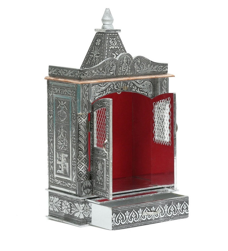 May include: A silver metal temple with intricate carvings and a red interior. The temple has a drawer at the bottom and a small door that opens to reveal the interior.