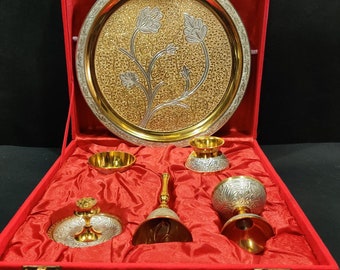 May include: A red velvet box with a gold and silver tray, two small bowls, a bell, and a cup. The tray has a floral design.