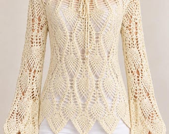 May include: A cream-colored long-sleeve crochet top featuring an intricate pineapple-inspired pattern, a wide scoop neckline with a central drawstring tie, and flared bell sleeves with a scalloped hemline that falls to a pointed finish.