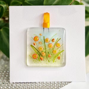 Carte de voeux suspendue à la main en verre fondu, prairie de fleurs d'oranger. Espace vide pour votre propre message. Convient à toutes les occasions. Cadeau dans une carte.
