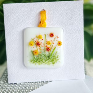 Carte de voeux suspendue à la main en verre fondu, prairie de fleurs d'oranger. Espace vide pour votre propre message. Convient à toutes les occasions. Cadeau dans une carte.