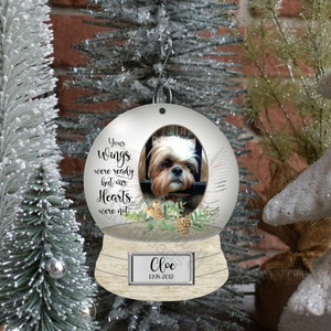 May include: A white snow globe ornament with a photo of a dog inside. The globe has a wooden base with a nameplate that reads "Chloe 1998-2012". The globe also has the text "Your wings were ready but our hearts were not" on the front.