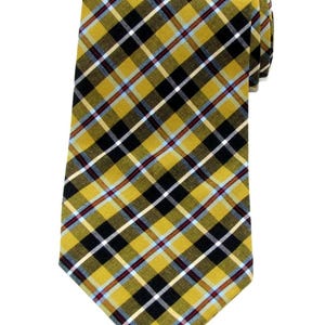 May include: A yellow, black, white, and blue plaid tie. The tie is rolled up and angled towards the upper right. The plaid pattern is a diagonal design. The tie is made of a woven fabric.