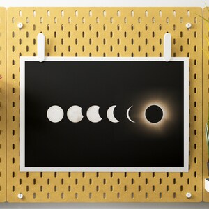 Op de afbeelding: Een zwart-witfoto van een zonsverduistering. De afbeelding toont de maan die voor de zon langs beweegt, waardoor een reeks sikkelvormen ontstaat. De laatste afbeelding toont de zon die volledig bedekt is door de maan, wat resulteert in een totale zonsverduistering.