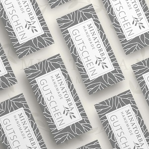 May include: A set of gray gift certificates with a white floral design and the text "MINATORBA HANDMADE GUTSCHEIN".