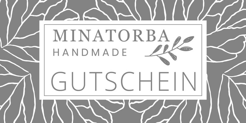 May include: A white rectangular gift certificate with a gray floral background. The text "MINATORBA HANDMADE GUTSCHEIN" is printed in white on the certificate.