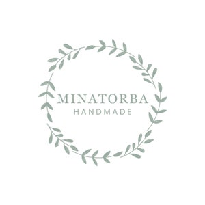 May include: A green leafy wreath with the text "MINATORBA HANDMADE" in the center.