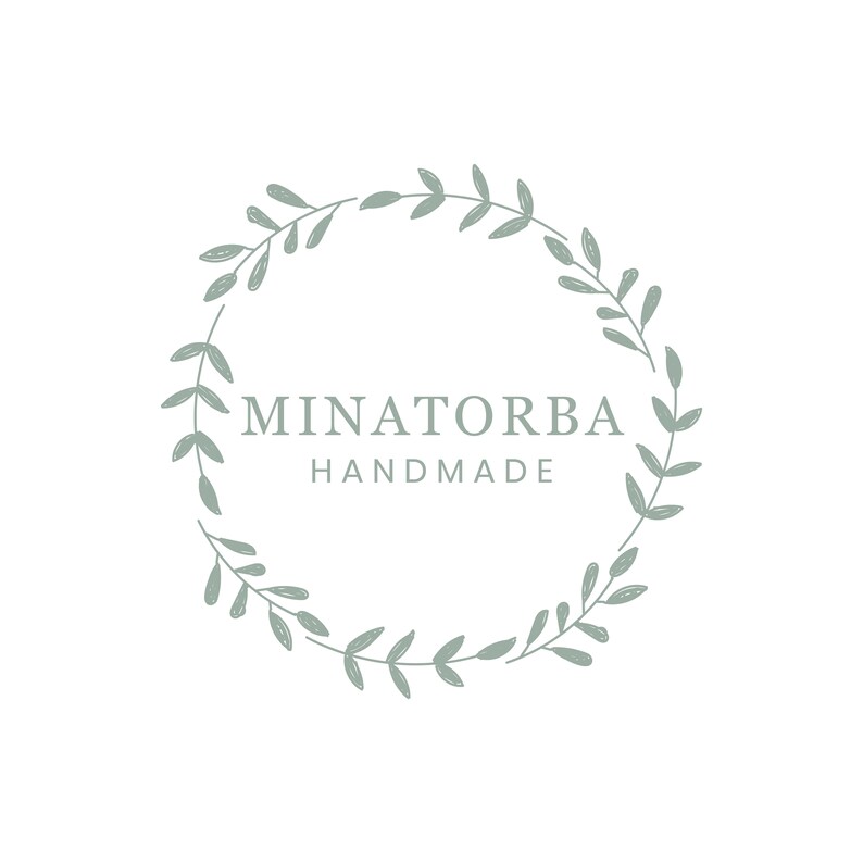 May include: A green leafy wreath with the text "MINATORBA HANDMADE" in the center.