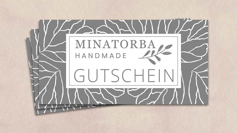 May include: A gray gift certificate with a white border and white text that reads "MINATORBA HANDMADE GUTSCHEIN". The background features a white floral pattern.