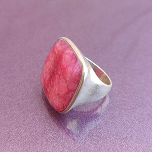 Peut inclure: Une bague en argent avec une grande pierre pr&eacute;cieuse carr&eacute;e rose sertie dans une b&eacute;li&egrave;re en or.