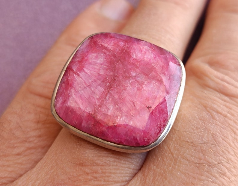 Peut inclure: Une bague en argent avec une grande pierre pr&eacute;cieuse carr&eacute;e rose. La pierre pr&eacute;cieuse a une surface rugueuse et textur&eacute;e.