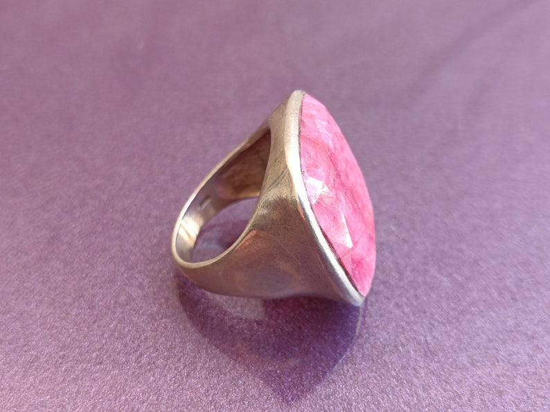 Peut inclure: Une bague en argent avec une grande pierre pr&eacute;cieuse rose facet&eacute;e sertie dans un sertissage &agrave; b&eacute;li&egrave;re.