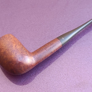 Puede incluir: Una pipa de madera marrón con una boquilla negra. La pipa está marcada con "Fine Quality by Mastro de Paja".