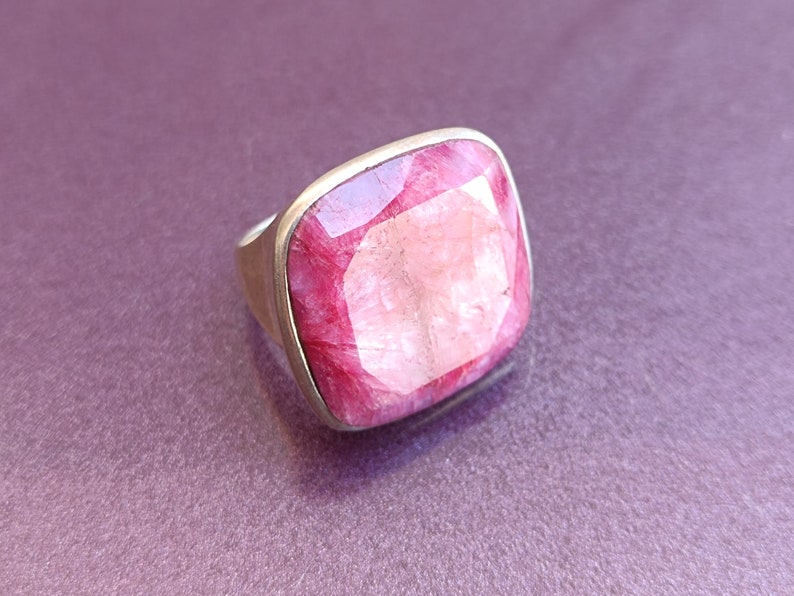 Peut inclure: Une bague en argent avec une grande pierre pr&eacute;cieuse rose de forme carr&eacute;e.