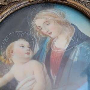 K&ouml;nnte beinhalten: Ovales antikes Portr&auml;t der Jungfrau Maria und des Jesuskindes, gerahmt in Goldfiligran. Das Kunstwerk zeigt weiche Pastellfarben, mit der Jungfrau Maria in einem blauen Umhang und dem Jesuskind mit Heiligenschein. Ein klassisches religi&ouml;ses Kunstwerk.