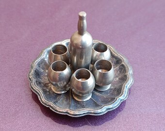 May include: A silver miniature serving set with a bottle and six glasses on a silver tray.