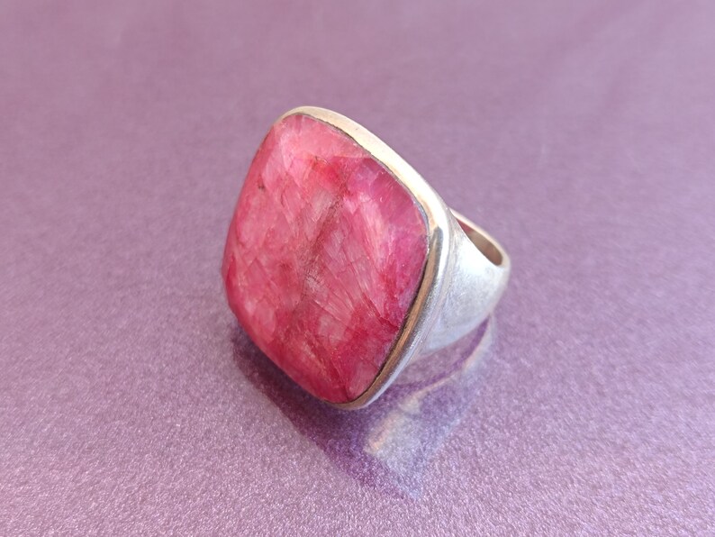 Peut inclure: Une bague en argent avec une grosse pierre pr&eacute;cieuse carr&eacute;e rose.