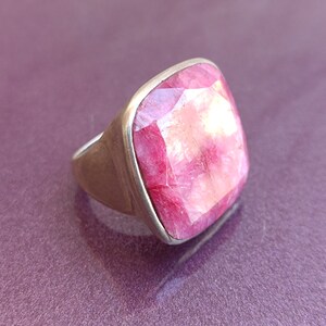 Peut inclure: Une bague en argent avec une grosse pierre pr&eacute;cieuse carr&eacute;e rose.