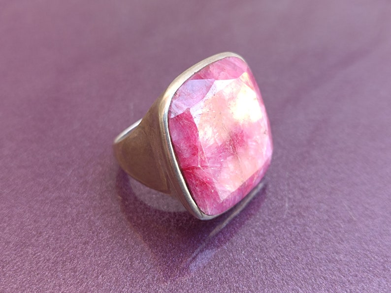Peut inclure: Une bague en argent avec une grosse pierre pr&eacute;cieuse carr&eacute;e rose.