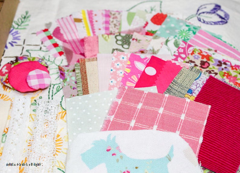 May include: A collection of pink, white, and green fabric scraps with a variety of patterns, including polka dots, stripes, and floral designs. The fabric scraps are arranged on a white surface and include a small, pink and white gingham fabric square.