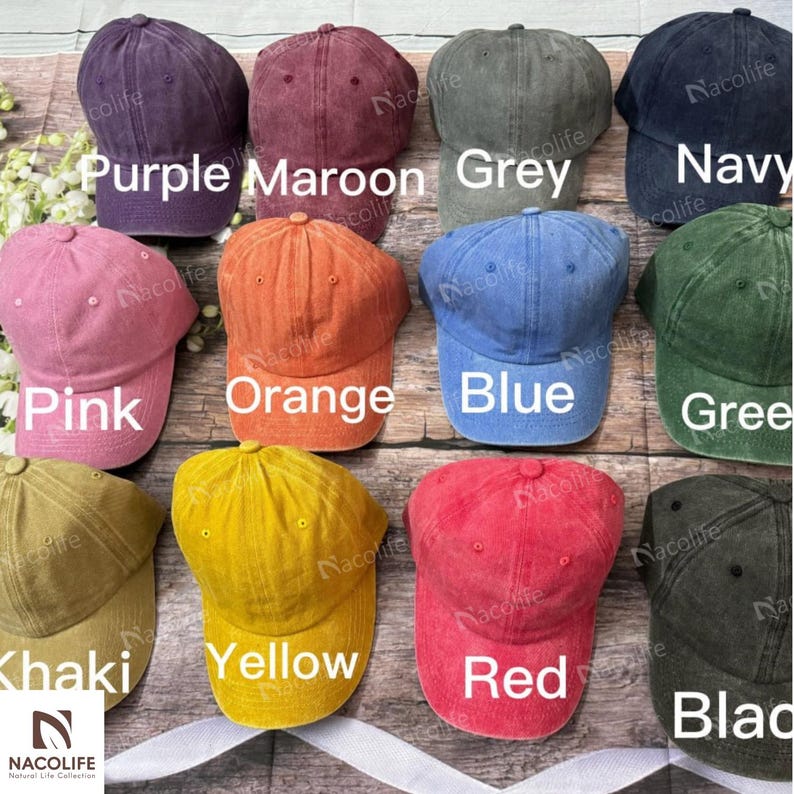 May include: A selection of baseball caps in a range of colours: purple, maroon, grey, navy, pink, orange, blue, green, khaki, yellow, red, and black. Each cap features a curved peak and an adjustable strap.