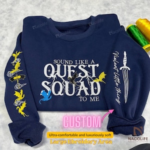 May include: A navy blue sweatshirt with a white embroidered design that says "Sound like a Quest Squad to me". The design includes a lightning bolt, a dragon, and a sword. The sweatshirt has a large embroidery area.