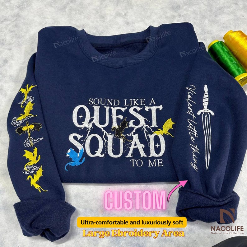 May include: A navy blue sweatshirt with a white embroidered design that says "Sound like a Quest Squad to me". The design includes a lightning bolt, a dragon, and a sword. The sweatshirt has a large embroidery area.