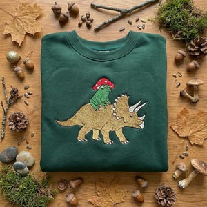 Bestickter Frosch Reit Triceratops Sweatshirt, Cottagecore Rundhalsausschnitt, Frosch Pilz Shirt, Kröte Dino Geschenk, Besticktes T-Shirt