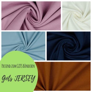 Könnte beinhalten: Eine Collage von Stoffmustern in den Farben Mauve, Creme, Hellblau, Marineblau und Braun. Der Stoff ist eng gewebt und hat eine sichtbare Textur. Text auf einer grünen Form: "PASSEND ZUM GOTS BÜNDCHEN Gots JERSEY."