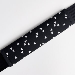 Op de afbeelding: Zwarte schouderband met een wit driehoeksmotief. De band is gevoerd voor comfort.