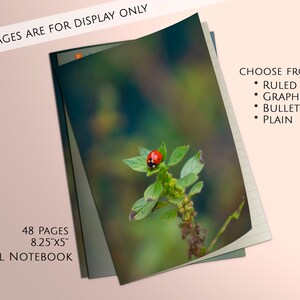 May include: A small notebook with a ladybug on a green leaf on the cover. The notebook has 48 pages and measures 8.25 inches by 5 inches. The notebook is available in ruled, graph, bullet, and plain styles.