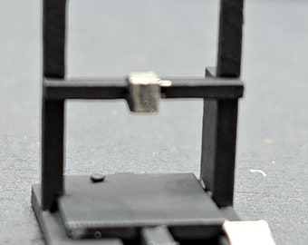 May include: A black 3D printer with a square print bed and a silver extruder head.