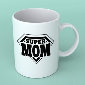 May include: White ceramic coffee mug with a black graphic of a superhero logo that says "SUPER MOM".