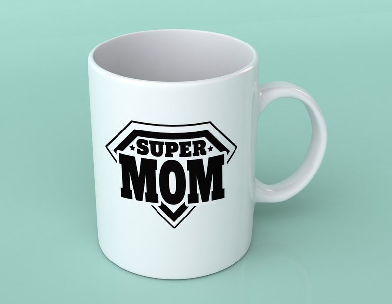May include: White ceramic coffee mug with a black graphic of a superhero logo that says "SUPER MOM".