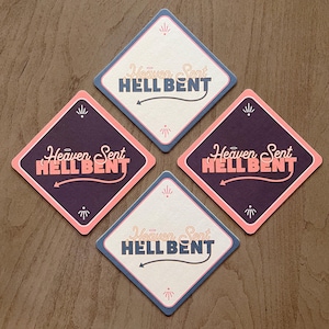 May include: Four diamond-shaped coasters with the text "Heaven Sent HELL BENT" in pink and blue lettering. The coasters are in different color combinations of white, pink, blue, and purple.