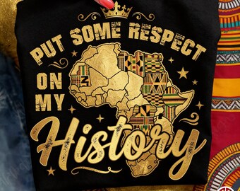 May include: Black t-shirt with gold text and a map of Africa. The text reads "PUT SOME RESPECT ON MY HISTORY" with a crown above the map. The map is filled with colorful patterns.